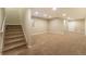Finished basement with carpeted floors, a staircase, and ample space for various uses at 5434 N Xenia St, Denver, CO 80238