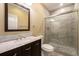 Modern bathroom with a vanity featuring double sinks, marble countertop, and glass-enclosed shower at 5434 N Xenia St, Denver, CO 80238