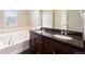 Bathroom features double sinks, granite countertops, bathtub, and dark cabinets at 5434 N Xenia St, Denver, CO 80238