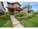 Inviting two-story home featuring a covered front porch, a well-maintained lawn, and mature landscaping at 5434 N Xenia St, Denver, CO 80238