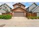 Two-story home featuring a single-car garage with natural wood trim and matching wooden fence at 5434 N Xenia St, Denver, CO 80238