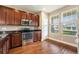 Modern kitchen features stainless steel appliances, dark cabinetry, and hardwood flooring at 5434 N Xenia St, Denver, CO 80238