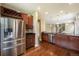 Kitchen features stainless steel refrigerator, dark cabinets, granite countertops and hardwood floors at 5434 N Xenia St, Denver, CO 80238