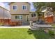 Spacious backyard features stone patio, artificial grass, and mature landscaping at 2587 Foothills Canyon Ct, Highlands Ranch, CO 80129