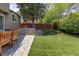 Charming backyard featuring a stone patio, a well-maintained lawn, and mature trees for added privacy at 2587 Foothills Canyon Ct, Highlands Ranch, CO 80129