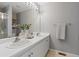 Well-lit bathroom featuring a double sink vanity, a large mirror, and tiled floors, adding functionality at 2587 Foothills Canyon Ct, Highlands Ranch, CO 80129