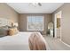 Comfortable bedroom boasts a carpeted floor, stylish window shutters, and a glimpse into the bathroom at 2587 Foothills Canyon Ct, Highlands Ranch, CO 80129