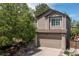 Exterior view of the home with a two-car garage and well-maintained landscaping at 2587 Foothills Canyon Ct, Highlands Ranch, CO 80129