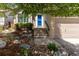 Charming front entrance with a blue door, stone steps, and mature trees at 2587 Foothills Canyon Ct, Highlands Ranch, CO 80129