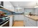 Bright kitchen featuring white cabinets, stainless steel appliances, and wood flooring at 2587 Foothills Canyon Ct, Highlands Ranch, CO 80129