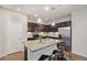 Stylish kitchen features dark wood cabinets, stainless steel appliances, and a granite island with seating at 16141 Bolling Dr, Denver, CO 80239
