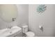 Cozy powder room featuring a round mirror and elegant wall decor, creating a simple design at 16141 Bolling Dr, Denver, CO 80239