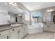 Bathroom featuring a soaking tub, double vanity, and plenty of natural light at 853 Stagecoach Dr, Lafayette, CO 80026