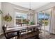 Well-lit dining room featuring a wooden table, a modern chandelier, and a view of the beautiful backyard at 853 Stagecoach Dr, Lafayette, CO 80026