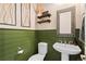 Charming powder room with green wainscoting, pedestal sink, and decorative mirror at 853 Stagecoach Dr, Lafayette, CO 80026