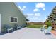 Expansive backyard with a spacious concrete patio, lush lawn, and mature trees, providing the perfect outdoor escape at 803 W Lucerne Dr, Lafayette, CO 80026