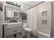 Charming bathroom features a tiled shower-tub with storage niche, framed mirror, and a decorative dotted shower curtain at 803 W Lucerne Dr, Lafayette, CO 80026