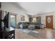Bright living room boasts a sectional sofa, a patio door, and a tiled floor, creating a cozy and inviting atmosphere at 803 W Lucerne Dr, Lafayette, CO 80026