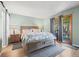 Comfortable main bedroom with a bed, bedside tables, hardwood floors, and a sliding glass door to the back patio at 803 W Lucerne Dr, Lafayette, CO 80026