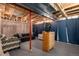 Partially finished basement featuring exposed beams and ductwork, a television, and seating arrangements at 5033 Goshawk Ct, Brighton, CO 80601