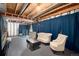 Partially finished basement featuring exposed beams and ductwork, blue curtains, and seating arrangements at 5033 Goshawk Ct, Brighton, CO 80601