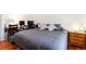 Spacious bedroom featuring a large bed, hardwood floors, and a side table with lamp at 5033 Goshawk Ct, Brighton, CO 80601