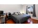 Comfortable bedroom with hardwood floors, gray bedding, and a window providing natural light at 5033 Goshawk Ct, Brighton, CO 80601