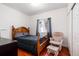 Cozy bedroom with wood floors, and natural light from the window with a comfortable chair and ottoman at 5033 Goshawk Ct, Brighton, CO 80601