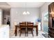 Cozy dining room featuring a chandelier, a wooden table with seating for four, and easy access to the kitchen at 5033 Goshawk Ct, Brighton, CO 80601
