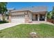 Charming single-story home featuring a well-kept lawn, inviting front porch, and a two-car garage with stylish brick accents at 5033 Goshawk Ct, Brighton, CO 80601