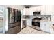 Modern kitchen with stainless steel appliances, white cabinets, mosaic backsplash and plenty of countertop space at 5033 Goshawk Ct, Brighton, CO 80601