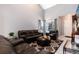 Living room featuring comfortable leather furniture, large windows, and a stylish rug creating an inviting space at 5033 Goshawk Ct, Brighton, CO 80601