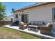 An outdoor patio with comfortable seating arrangements, with a sliding door to the house, and a backyard view at 5033 Goshawk Ct, Brighton, CO 80601