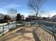 Deck overlooking a fenced backyard with mature trees and neighboring homes at 1090 Quail Cir, Brighton, CO 80601