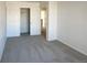 Spacious bedroom with grey carpet, double closet, and access to hallway at 1090 Quail Cir, Brighton, CO 80601