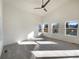 Sunlit living room with vaulted ceiling, carpet and multiple windows at 1090 Quail Cir, Brighton, CO 80601