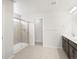 Bright bathroom featuring dual sinks, a glass-enclosed shower, and neutral tile flooring at 17424 E 90Th Pl, Commerce City, CO 80022