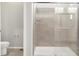 Bathroom featuring glass enclosed shower with tiled walls and a modern toilet at 17424 E 90Th Pl, Commerce City, CO 80022