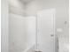 The bathroom has a shower over the tub with tile surround and a white door at 17424 E 90Th Pl, Commerce City, CO 80022