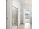 Ensuite bathroom with glass enclosed shower, tile floors, and view into bedroom at 17424 E 90Th Pl, Commerce City, CO 80022