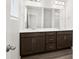 Modern bathroom featuring double sinks, dark vanity, and sleek countertops for a luxurious feel at 17424 E 90Th Pl, Commerce City, CO 80022