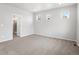 Bedroom with plush carpet, three bright windows, and a door leading to bathroom at 17424 E 90Th Pl, Commerce City, CO 80022