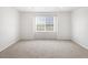 Cozy bedroom featuring neutral carpet, white walls, and a window for natural light at 17424 E 90Th Pl, Commerce City, CO 80022