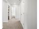 Hallway with carpet and bright white paint leading to the bathroom and laundry area at 17424 E 90Th Pl, Commerce City, CO 80022