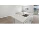 Modern kitchen island boasts stainless steel sink, quartz countertop, and seating at 17424 E 90Th Pl, Commerce City, CO 80022
