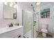 Bright bathroom featuring a glass-enclosed shower, modern vanity with a white countertop, and wood-look flooring at 2767 W 38Th Ave, Denver, CO 80211