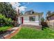 Charming home with a red front door, rock foundation, fresh green lawn, and beautiful landscaping at 2767 W 38Th Ave, Denver, CO 80211