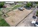 An aerial view showcases the horse arena, surrounding outbuildings, and the main residence at 16225 W 74Th Dr, Arvada, CO 80007