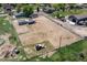 Aerial view displays the property featuring a horse arena, outbuildings, house and rural surroundings at 16225 W 74Th Dr, Arvada, CO 80007