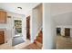 Welcoming entryway featuring a wood door, tile flooring, and staircase with a view of the adjacent living area at 16225 W 74Th Dr, Arvada, CO 80007